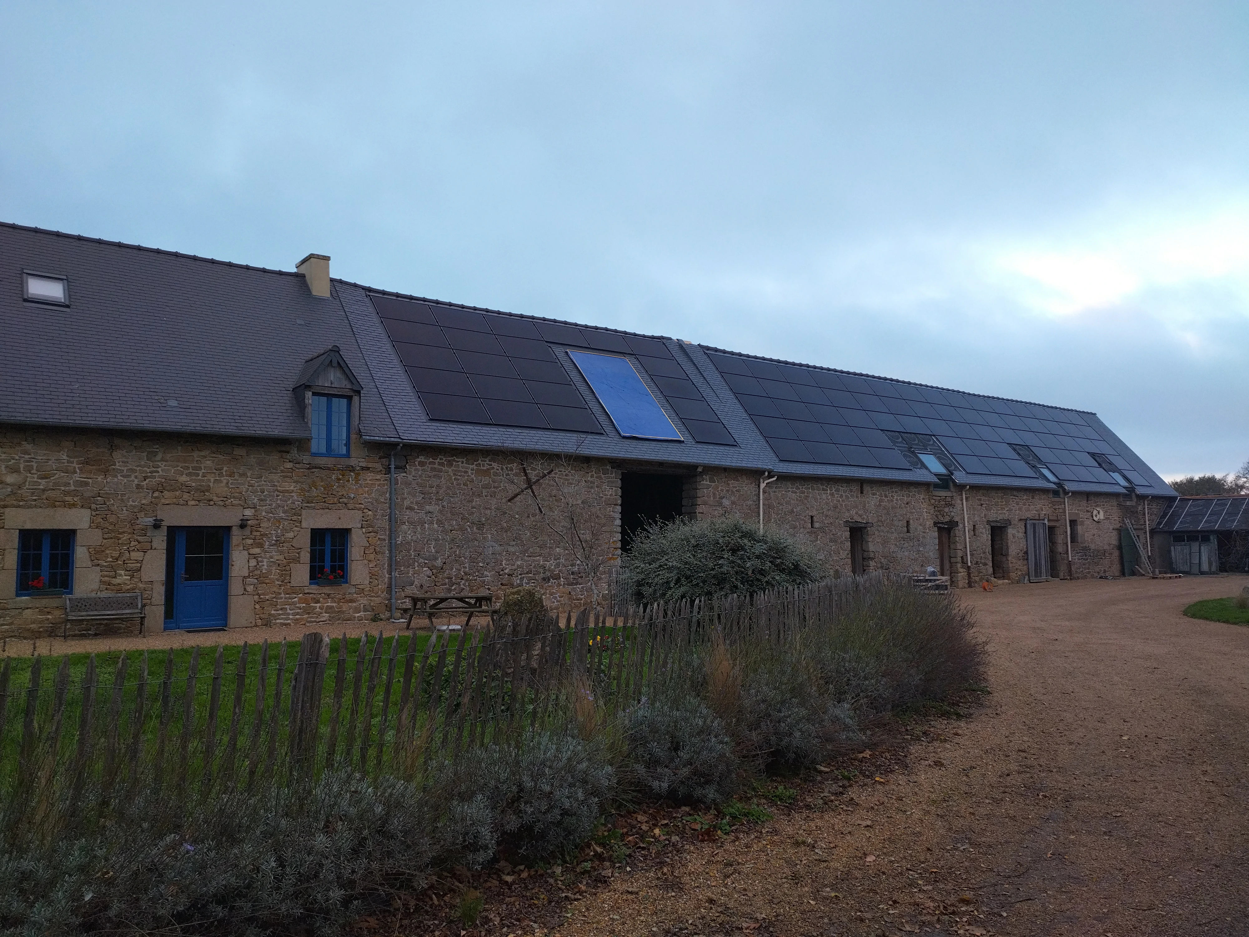 Vue d'ensemble d'une rénovation complète d'une toiture en ardoise avec des panneaux solaires par Couverture Delalande.